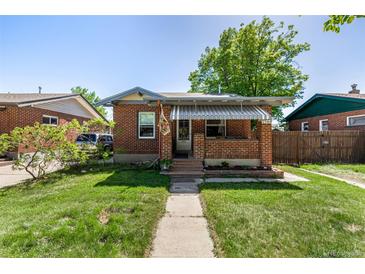 Charming brick home featuring a covered front porch and well-maintained lawn at 2564 S Acoma St, Denver, CO 80223