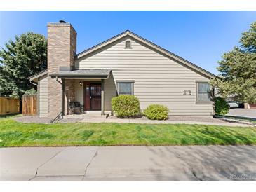 Charming home exterior featuring a brick chimney, covered porch, and well-maintained landscaping at 10836 W Evans Ave # 29, Lakewood, CO 80227