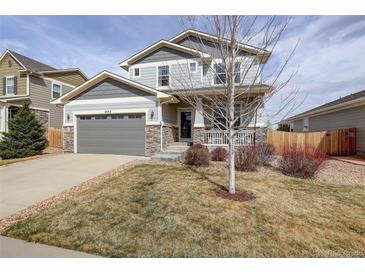 Charming two-story home featuring a two-car garage, stone accents, and a cozy front porch at 2033 E 167Th Way, Thornton, CO 80602