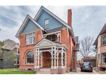 Stunning brick Victorian home with a covered porch, detailed trim, and classic architectural elements at 131 N Sherman St, Denver, CO 80203