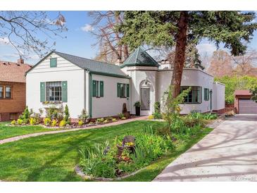 Charming home with a lush front yard, brick walkway and white painted brick at 1275 Birch St, Denver, CO 80220