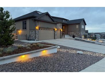 Charming home showcasing a two-car garage, stone accents, manicured front yard, and inviting curb appeal at 8023 Gore Creek Ln, Littleton, CO 80125