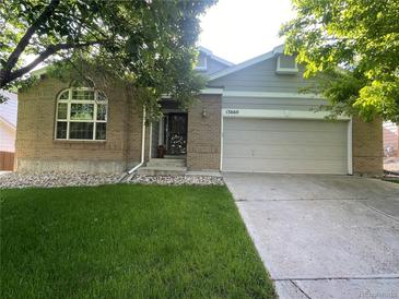 Charming brick home with a well-maintained lawn and attached two-car garage at 13660 Monroe St, Thornton, CO 80602