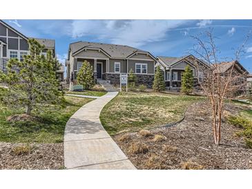 Charming one-story home featuring a landscaped front yard and a winding concrete walkway at 1104 Brocade Dr, Littleton, CO 80126
