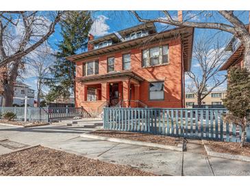 Charming two-story red brick home with a covered porch and a blue picket fence at 1401 N Franklin St # 2, Denver, CO 80218