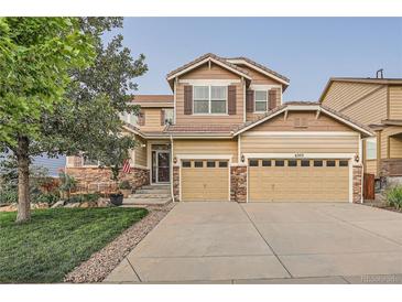 Charming two-story home with a well-manicured lawn, complemented by a two-car garage and stone accents at 6302 S Jackson Gap Ct, Aurora, CO 80016