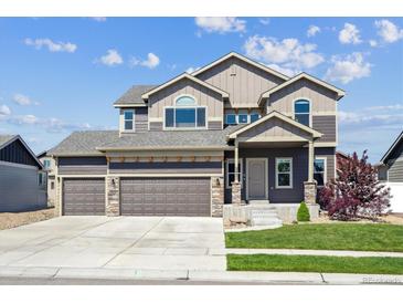 Beautiful two-story home boasts a three-car garage, manicured lawn and stone accents, offering modern comfort at 2431 Nicholson St, Berthoud, CO 80513