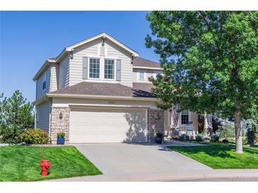 Charming two-story home with stone accents, a well-maintained lawn, and a two car garage at 860 Bramblewood Dr, Castle Pines, CO 80108