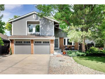 Charming two-story home with gray siding, brick accents, attached two-car garage, and well-maintained landscaping at 7869 S Valentia St, Centennial, CO 80112