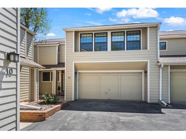 Two-story townhouse featuring a one-car garage, and neutral-colored siding against a blue sky at 1011 Pierce St # 11, Lakewood, CO 80214