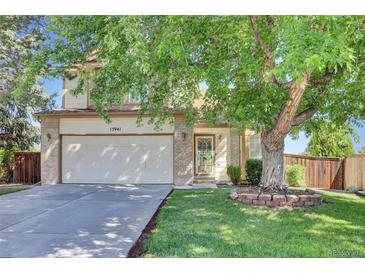 Inviting front exterior of home showcasing mature landscaping, brick accents, and a two-car garage at 15941 Bluebonnet Dr, Parker, CO 80134