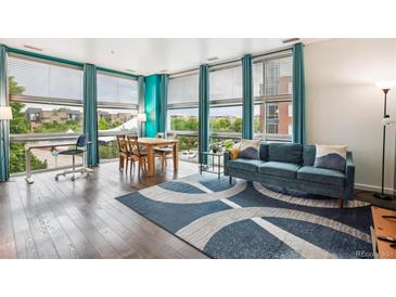 Bright living space with hardwood floors, modern furniture, and large windows with neighborhood views at 2958 Syracuse St # 317, Denver, CO 80238