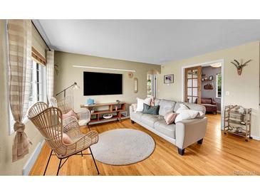 Cozy living room featuring hardwood floors, a comfortable sofa, and stylish decor at 1243 S Tejon St, Denver, CO 80223