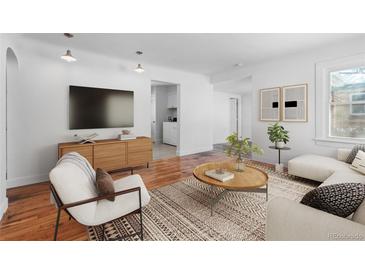 Bright living room boasts hardwood floors, a modern media center, and a cozy seating area at 1570 Xanthia St, Denver, CO 80220
