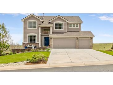 Charming two-story home featuring a three-car garage and a well-manicured front lawn at 6950 Blue Mesa Ln, Littleton, CO 80125