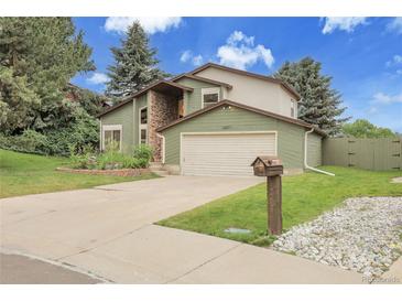 Charming home featuring stone accents, a well-manicured lawn, and a two-car garage at 12671 W Dakota Dr, Lakewood, CO 80228