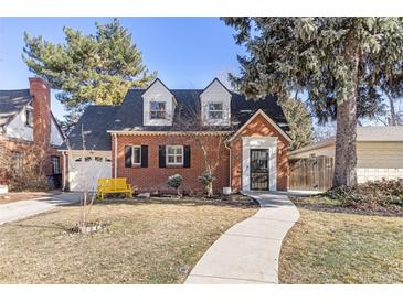 Charming brick home featuring dormer windows, a landscaped front yard and walkway leading to the front door at 700 Holly St, Denver, CO 80220