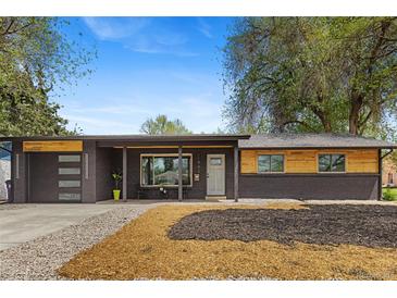 Charming exterior of a brick home featuring a modern garage and inviting front porch at 982 S Holly St, Denver, CO 80246
