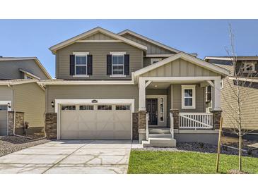 Charming two-story home featuring a welcoming front porch and a two-car garage at 16686 E 110Th Ave, Commerce City, CO 80022
