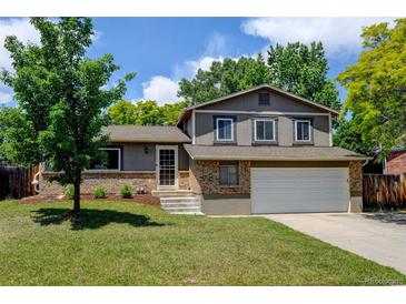 Charming two-story home with a well-maintained lawn and mature trees on a sunny day at 6775 Coors Ct, Arvada, CO 80004