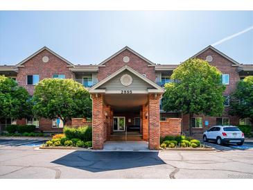 Inviting brick building entrance with well-maintained landscaping and convenient parking at 2895 W Riverwalk Cir # 104, Littleton, CO 80123