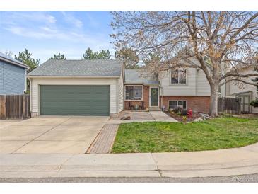 Charming home featuring an attached garage, well-maintained lawn, and tasteful landscaping at 6282 Yank Ct, Arvada, CO 80004