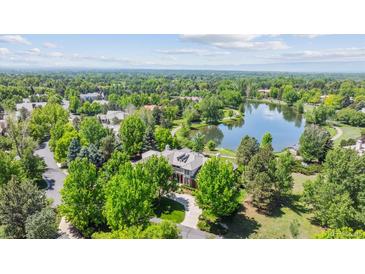 Stunning aerial view of a luxurious home nestled among lush greenery and a serene lake at 13 Buell Mansion Pkwy, Englewood, CO 80113
