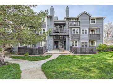 Attractive multi-level condominium with lawn, mature trees, and wood-look fencing at 7895 Allison Way # 203, Arvada, CO 80005