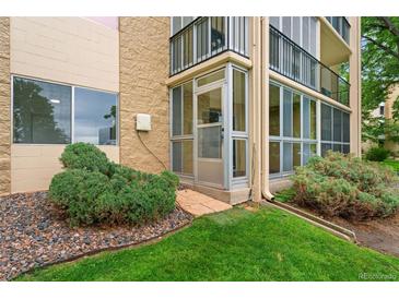 Exterior showing a building with enclosed lanai, landscaping and stone accents at 3022 S Wheeling Way # 109, Aurora, CO 80014