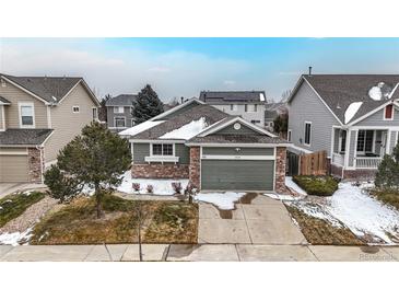 Charming home featuring a two-car garage, beautiful stone accents, and a well-maintained front lawn at 3906 S Quemoy Ct, Aurora, CO 80018