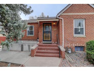 Inviting front door of brick home with covered porch and decorative security gate at 4850 E 18Th Ave, Denver, CO 80220