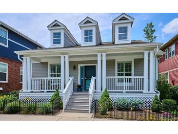 Charming home featuring a welcoming front porch, dormer windows, and well-manicured landscaping at 2723 Galena St, Denver, CO 80238