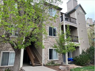 Condo exterior showing stone and siding, balcony and stairs leading to entrances and mature landscaping at 7429 S Alkire St # 205, Littleton, CO 80127