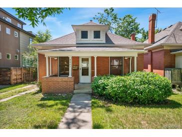 Charming brick home with a cozy front porch and well-maintained lawn at 4461 Vrain St, Denver, CO 80212