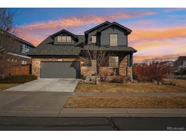 Charming two-story home featuring a stone facade, attached garage, and landscaped front yard at 25123 E 5Th Ave, Aurora, CO 80018