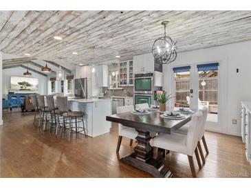 A dining area that features a wood table with seating adjacent to the kitchen island with barstool seating at 11542 W 67Th Way, Arvada, CO 80004