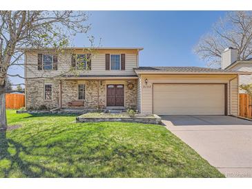 Charming two-story home featuring brick accents, a well-manicured lawn, and a spacious two car garage at 5157 S Sedalia Ct, Centennial, CO 80015