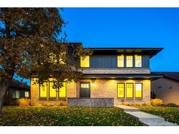 Stunning two-story home with brick and wood siding, a landscaped lawn, and a walkway at 1110 Elm St, Denver, CO 80220