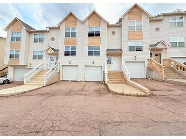 View of townhomes with a private garages and steps leading up to the front doors at 94 Vale St, Palmer Lake, CO 80133