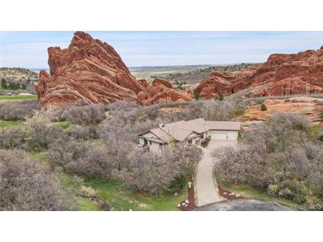 Secluded home with tile roof situated amongst mature trees and monumental red rock formations creates a natural hideaway at 5688 Red Fern Ct, Littleton, CO 80125