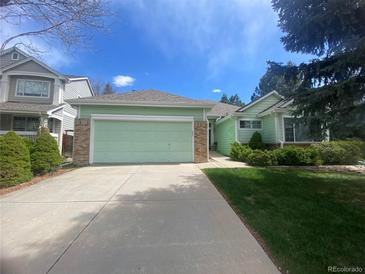Charming single Gathering house with green painted wood, brick accents, and a concrete driveway at 9806 Hooker Ct, Westminster, CO 80031