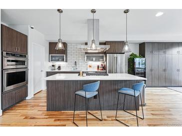 Modern kitchen boasts a large island with seating and stylish stainless steel appliances at 3201 W 25Th Ave, Denver, CO 80211