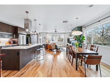 Open floor plan showcasing the kitchen, dining, and living area with hardwood floors and natural light at 3201 W 25Th Ave, Denver, CO 80211