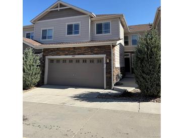 Charming two-story townhome with a stone facade and attached garage at 14883 E Crestridge Dr, Centennial, CO 80015