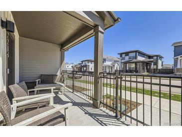 Cozy covered front porch with seating and a view of the street at 2214 Central Park Way, Superior, CO 80027
