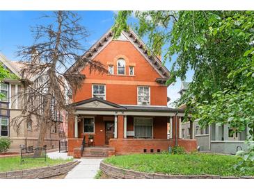 Charming red brick two-story home featuring a welcoming front porch and classic architectural details at 1136 N Logan St # 8, Denver, CO 80203