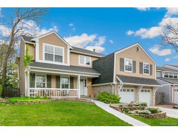 Charming two-story home featuring a welcoming front porch, manicured lawn, and a two-car garage at 6340 E Costilla Pl, Centennial, CO 80112