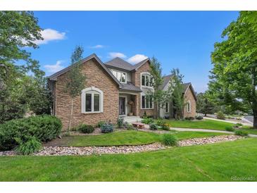Charming home with stone accents, mature trees, and manicured lawn in a desirable neighborhood at 1999 Champions Cir, Castle Rock, CO 80104