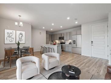 Open concept living room with modern kitchen, dining area, and stylish furnishings at 487 Interlocken Blvd # 307, Broomfield, CO 80021