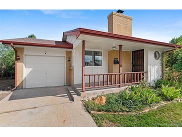 Charming single-story home featuring a brick chimney and a cozy front porch with manicured lawn at 2582 Beech Ct, Golden, CO 80401